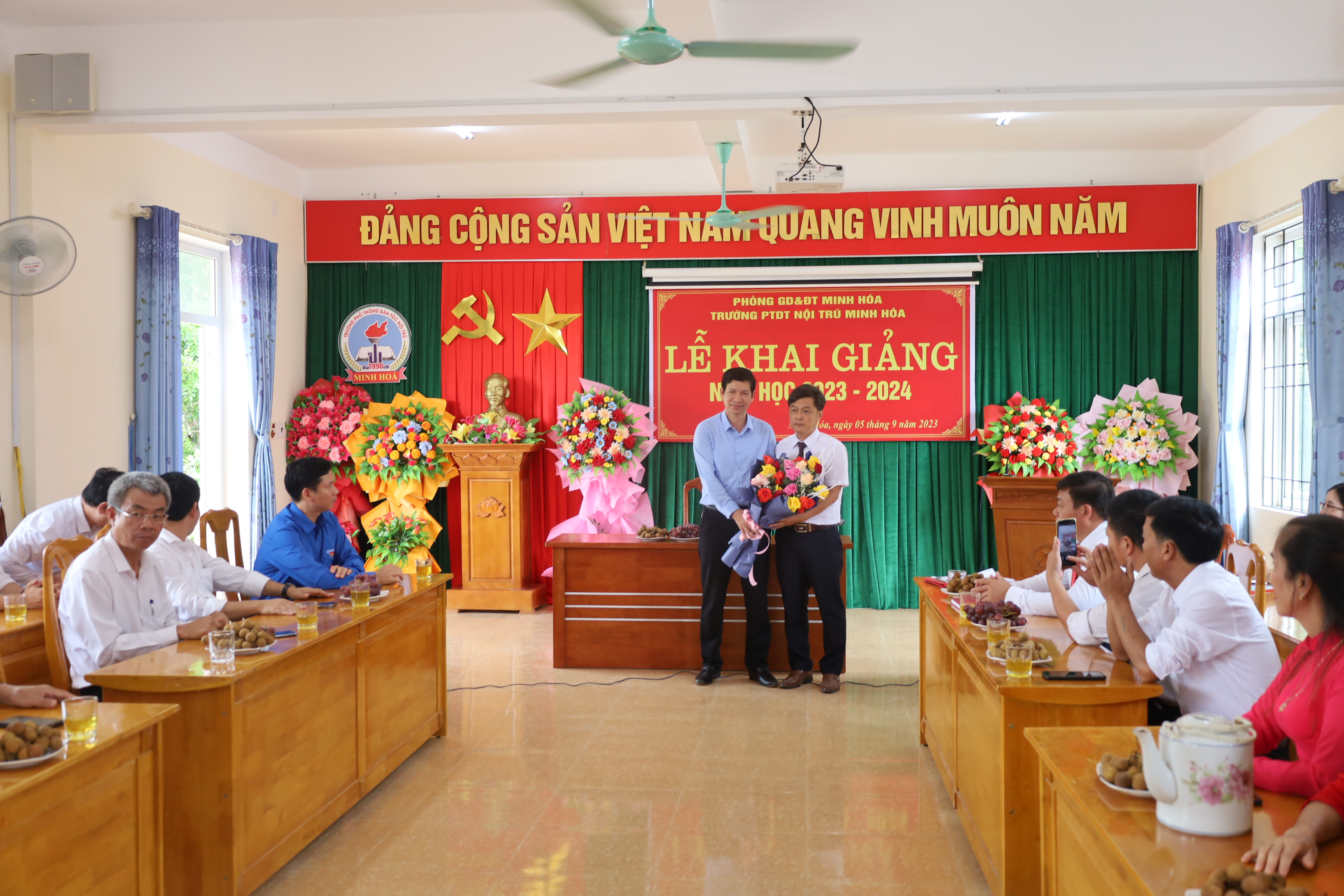 Đồng chí Hồ An Phong, Tỉnh ủy viên, Phó Chủ tịch UBND tỉnh tặng hoa chúc mừng Trường Phổ thông Dân tộc nội trú huyện Minh Hóa nhân ngày khai giảng năm học mới.