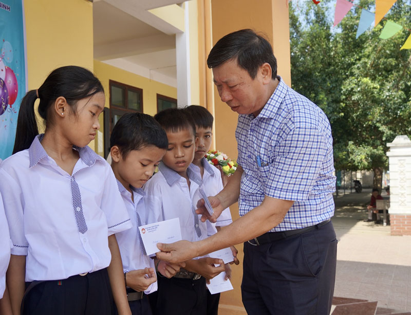 Đại diện Ủy ban MTTQVN huyện Quảng Ninh trao quà cho các học sinh có hoàn cảnh khó khăn trên địa bàn.