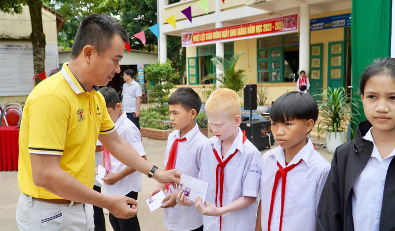 Đại diện CLB GolF G76 (TP. Hồ Chí Minh) trao quà cho học sinh trường Trường PTDT bán trú tiểu học và THCS Dân Hóa (huyện Minh Hóa).