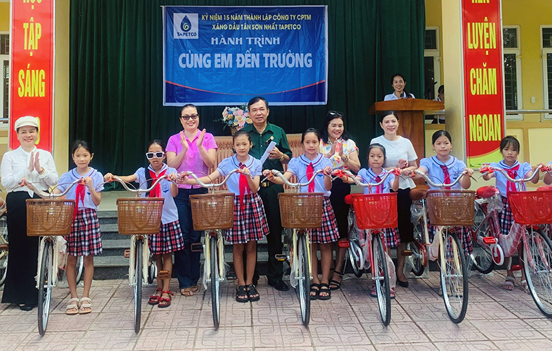 Đại diện Công ty CP Thương mại Xăng dầu Tân Sơn Nhất-Tapetco trao tặng xe đạp cho các em học sinh có hoàn cảnh khó khăn trên địa bàn huyện Quảng Ninh.