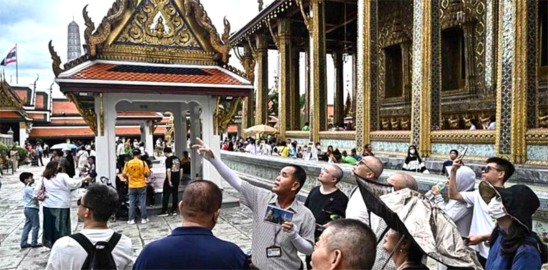  Hướng dẫn viên Thái Lan dẫn đoàn khách Trung Quốc đi thăm một cung điện tại Bangkok. Ảnh: AFP