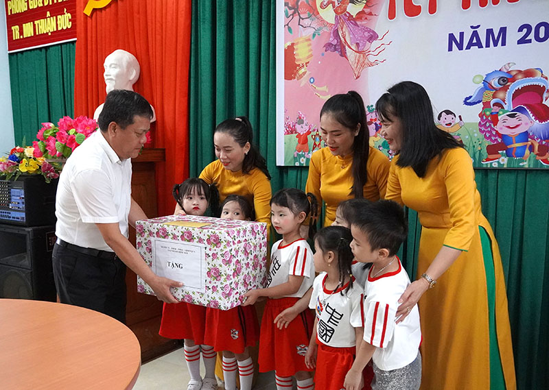 Đồng chí Bí thư Thành ủy Đồng Hới tặng quà cô và trò Trường mầm non Thuận Đức.