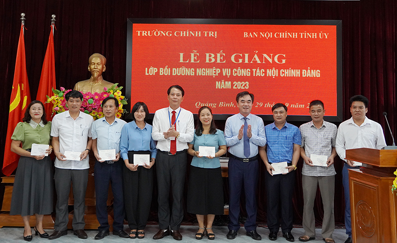 Đồng chí Trưởng ban Nội chính Tỉnh ủy Nguyễn Lương Bình và đồng chí Đặng Ngọc Bắc, Phó Hiệu trưởng Trường Chính trị tỉnh trao thưởng cho các học viên có thành tích xuất sắc.