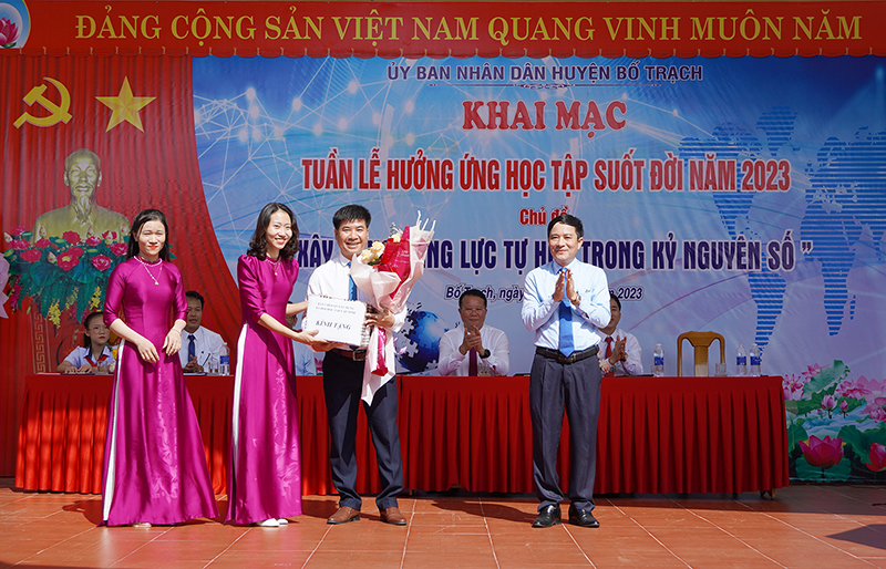Thay mặt Ban Chỉ đạo Xây dựng xã hội học tập tỉnh, đồng chí Hà Quốc Phong, Phó Giám đốc Sở Văn hóa-Thể thao, tặng hoa chúc mừng đơn vị phát động điểm của huyện Bố Trạch.