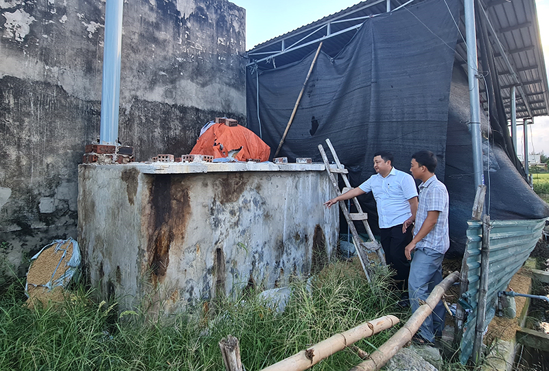 Lãnh đạo UBND xã Duy Ninh kiểm tra hệ thống xử lý khí thải tại cơ sở ép củi trấu của ông Lê Văn Thục.