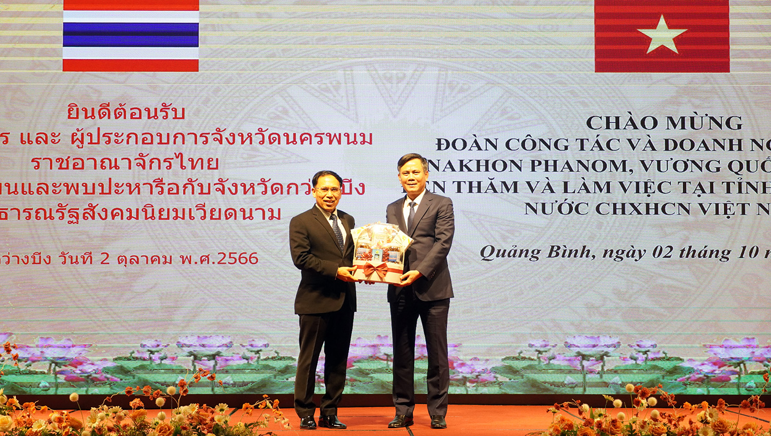 Đồng chí Chủ tịch UBND tỉnh Quảng Bình Trần Thắng và Tỉnh trưởng tỉnh Na-khon Pha-nôm Văn-chay Chăn-phon trao quà lưu niệm cho nhau