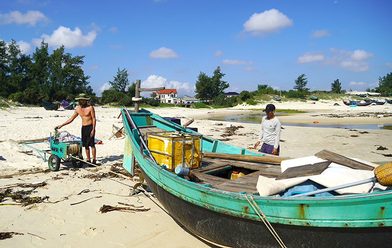 Ngư dân điều khiển máy tời kéo thuyền lên bờ.