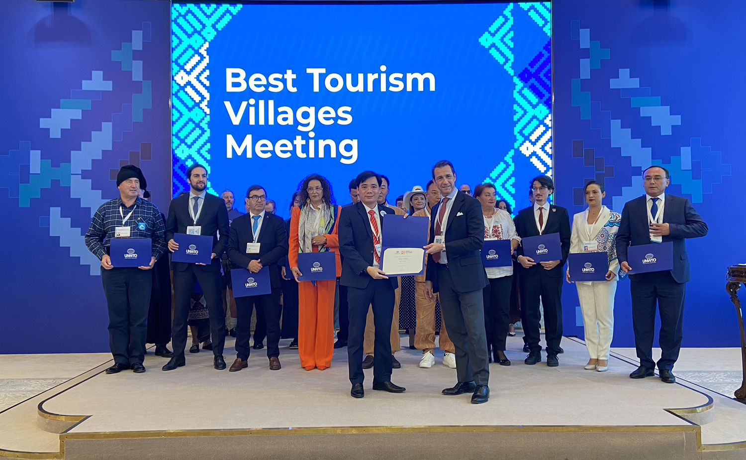Đại diện UBND xã Tân Hóa nhận giải thưởng của Tổ chức Du lịch thế giới.