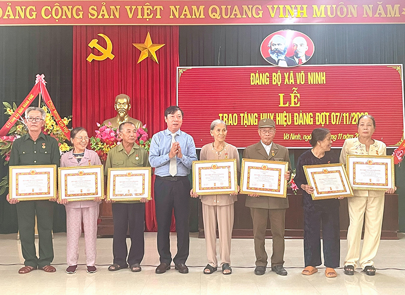 Đồng chí Lê Chí Huy, Chủ tịch Ủy ban MTTQVN huyện Quảng Ninh trao Huy hiệu đảng cho các đảng viên ở Đảng bộ xã Võ Ninh.