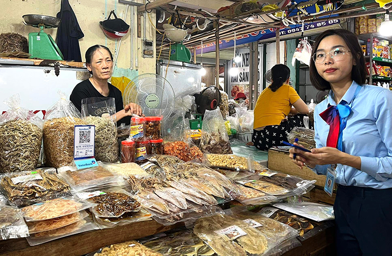 Nhân viên Vietinbank Quảng Bình triển khai cung cấp mã QR Code cho các tiểu thương chợ truyền thống.