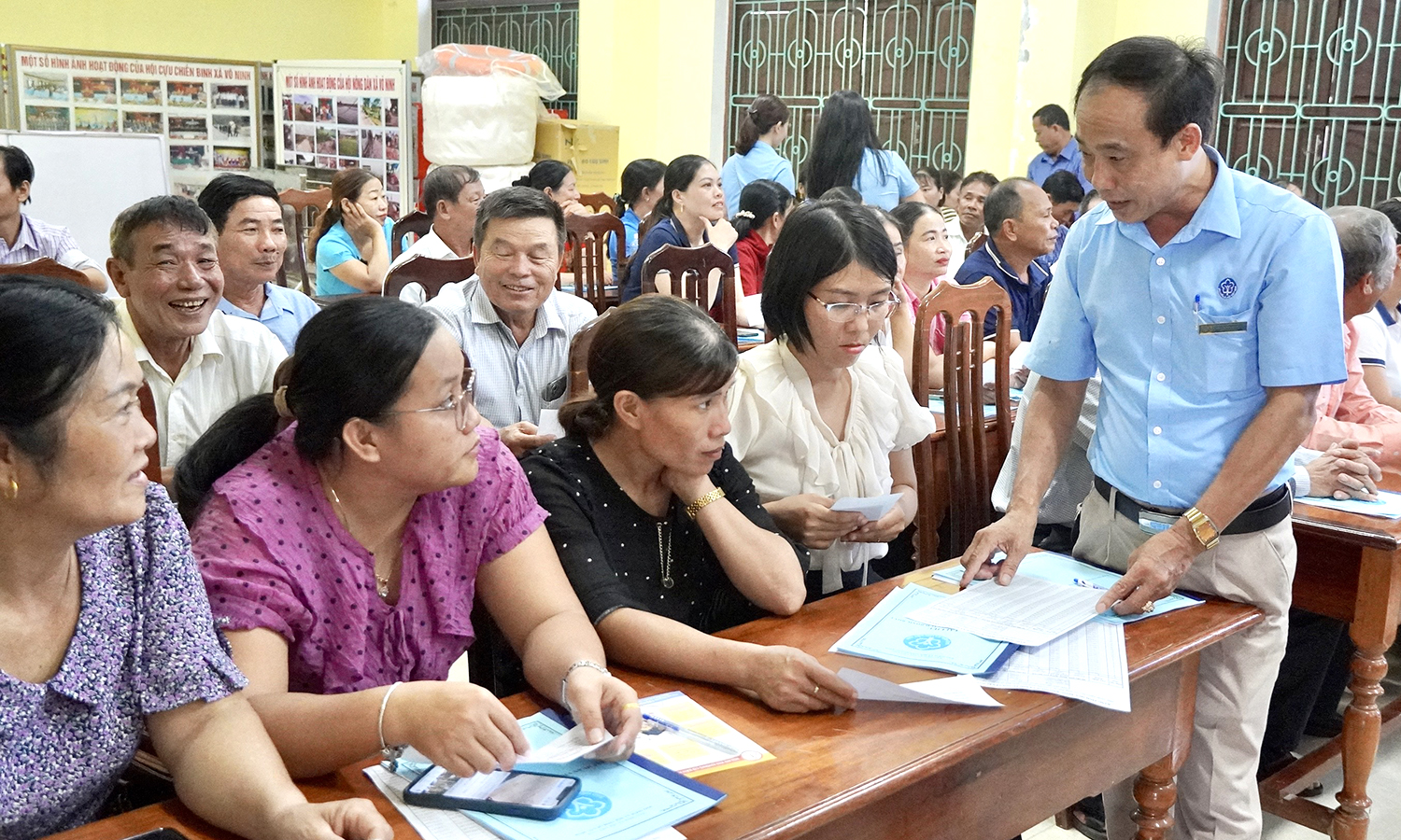 Cán bộ BHXH huyện Quảng Ninh trao đổi về chính sách BHXH tự nguyện, bảo hiểm y tế cho người dân.