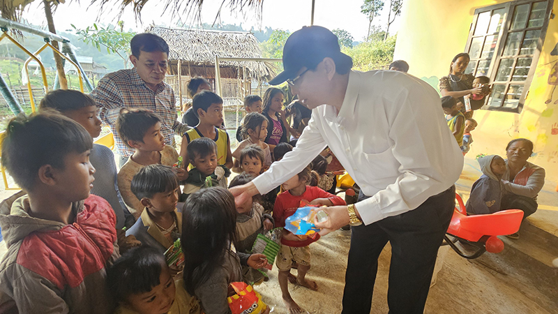 Các đồng chí trong đoàn tặng quà cho các em học sinh người Ma Coong ở xã Thượng Trạch (Bố Trạch).