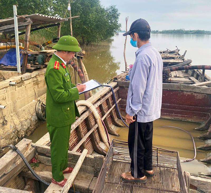 Công an xã Hàm Ninh tiến hành lập biên bản về hành vi khai thác cát trái phép của ông Hoàng Văn Trọng.