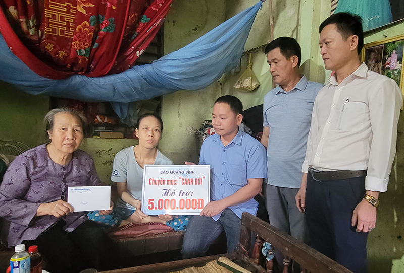 Phóng viên Báo Quảng Bình và đại diện lãnh đạo xã Mỹ Thủy, Chi bộ thôn Thống Nhất trao quà cho gia đình ông Huỳnh, bà Tiến.