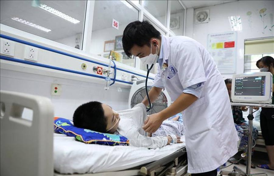 Bác sỹ theo dõi sức khỏe cho một bệnh nhi. (Ảnh: PV/Vietnam+)