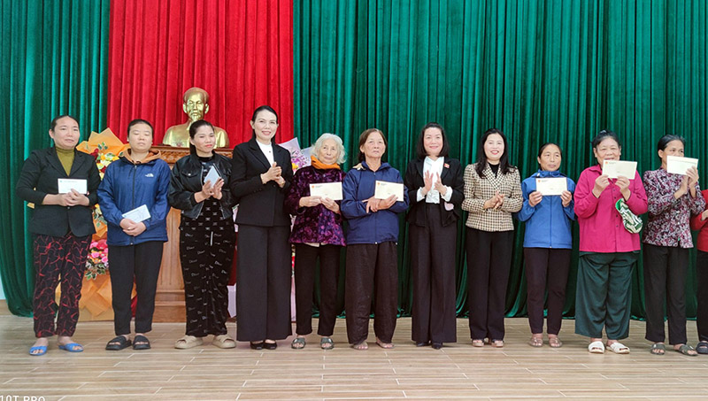 Đồng chí Phó trưởng đoàn chuyên trách Đoàn đại biểu Quốc hội tỉnh Nguyễn Minh Tâm và lãnh đạo Hội LHPN tỉnh trao quà cho chị em hội viên thôn Cồn Sẻ