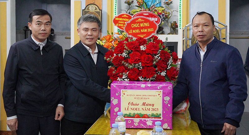 Đồng chí Phó Bí thư Thường trực Huyện ủy Bố Trạch Trần Văn Thăng tặng hoa chúc mừng Giáng sinh giáo xứ Thanh Hải (xã Thanh Trạch, Bố Trạch).
