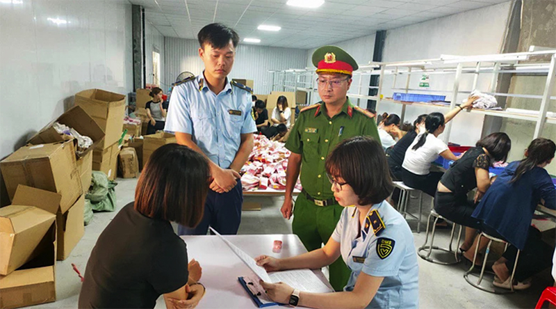Lực lượng Quản lý thị trường phối hợp với lực lượng Công an kiểm tra một kho hàng vi phạm.