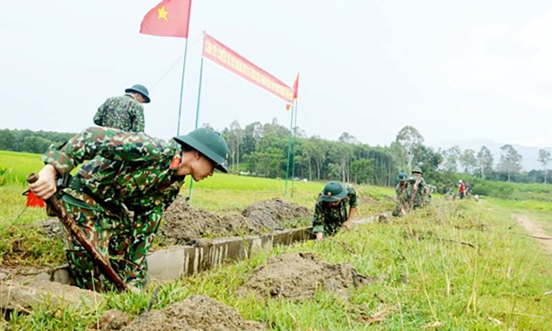 Cán bộ, chiến sĩ Tiểu đoàn 5, Trung đoàn 142, Sư đoàn 315 giúp nhân dân xã Tam Mỹ Tây, huyện Núi Thành, (Quảng Nam) nạo vét kênh mương. Ảnh: VĂN TUÂN