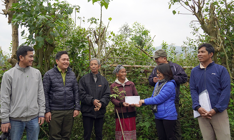 Cán bộ Trung tâm Bảo tồn Thiên nhiên Việt khen thưởng hộ dân bản Cổ Tràng đã trồng và chăm sóc cây hiệu quả.