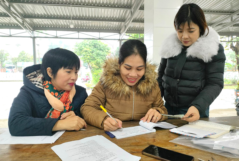 Nhân viên thu làm thủ tục đóng BHXH tự nguyện cho người dân.