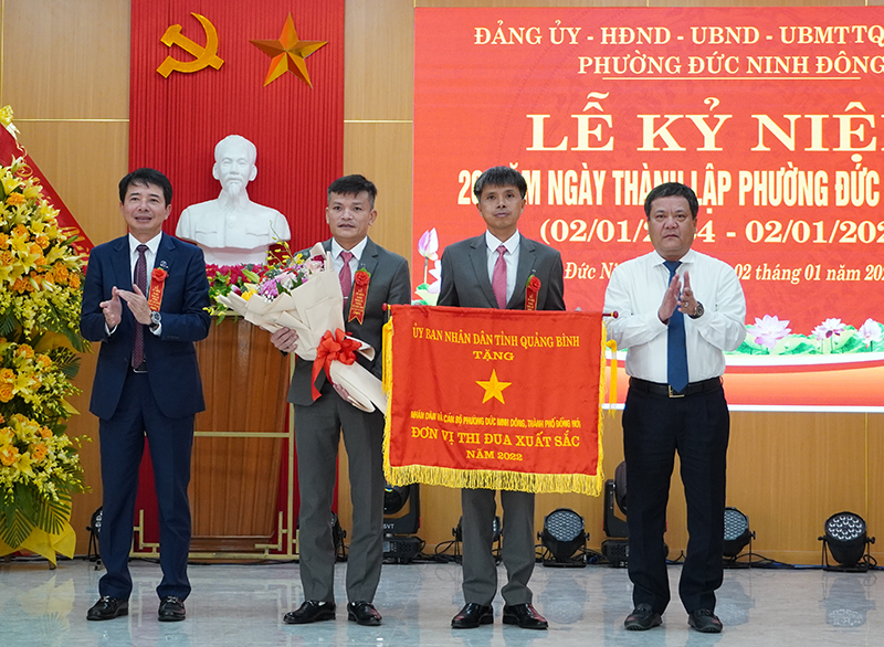 Đồng chí Bí thư Thành ủy Đồng Hới Trần Phong và Chủ tịch UBND thành phố Hoàng Ngọc Đan trao cờ thi đua của UBND tỉnh tặng phường Đức Ninh Đông.