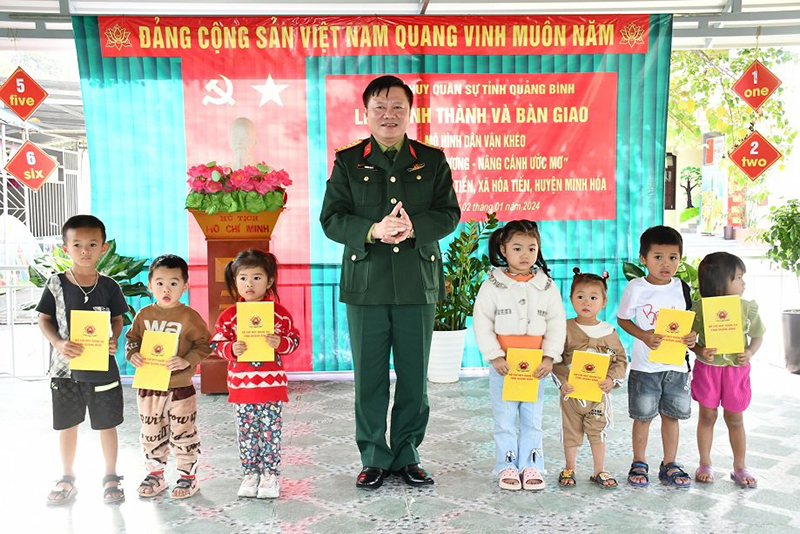 Đại tá Trương Như Ý, Phó Chính ủy Bộ CHQS tỉnh tặng quà cho các cháu học sinh.