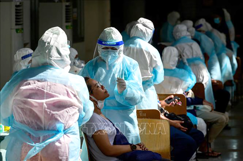  Nhân viên y tế lấy mẫu xét nghiệm COVID-19 tại Bangkok, Thái Lan. Ảnh tư liệu: AFP/TTXVN