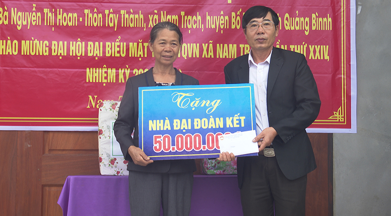Đại diện lãnh đạo Ủy ban MTTQVN huyện Bố Trạch trao tiền hỗ trợ cho bà Nguyễn Thị Hoan.