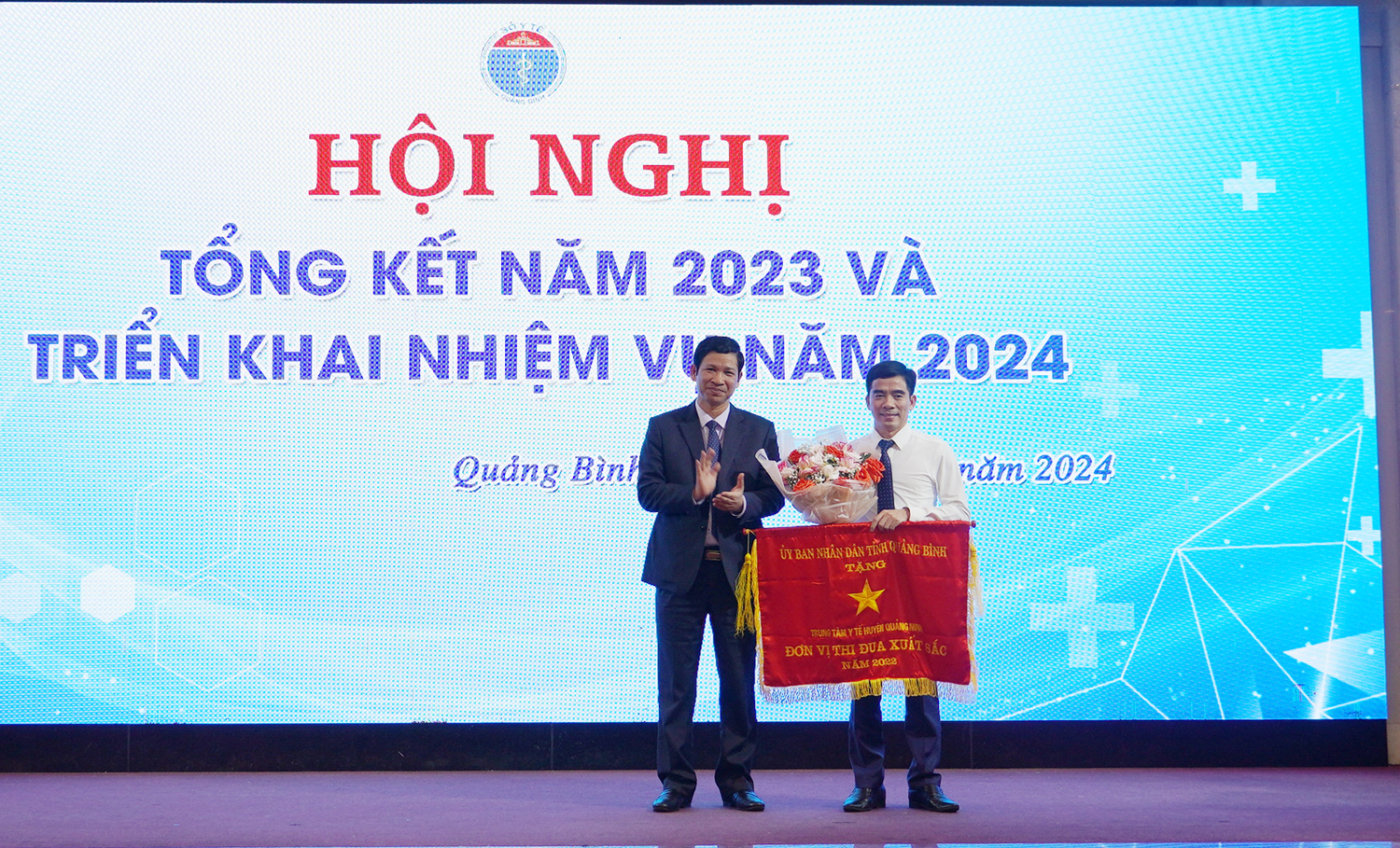 Đồng chí Phó Chủ tịch UBND tỉnh Hồ An Phong trao Cờ thi đua xuất sắc cho Trung tâm Y tế huyện Quảng Ninh.