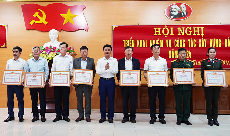 Đồng chí Bí thư Huyện uỷ Quảng Ninh Trần Quốc Tuấn trao giấy khen cho các tổ chức cơ sở đảng đạt tiêu chuẩn hoàn thành xuất sắc nhiệm vụ.