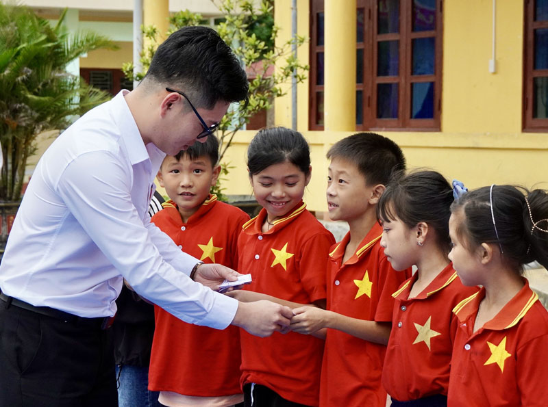Đại diện đơn vị tài trợ-Bệnh viện đa khoa TTH Quảng Bình trao thẻ cho các em học sinh.