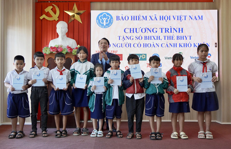 Đại diện lãnh đạo BHXH tỉnh trao tặng thẻ BHYT cho các học sinh hoàn cảnh khó khăn trên địa bàn huyện Quảng Ninh.