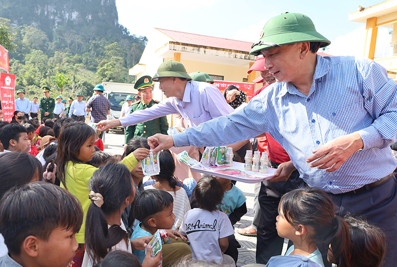  Đồng chí Phó Bí thư Thường trực Tỉnh ủy Trần Hải Châu ân cần chuyện trò và phát sữa cho trẻ em xã Tân Trạch.
