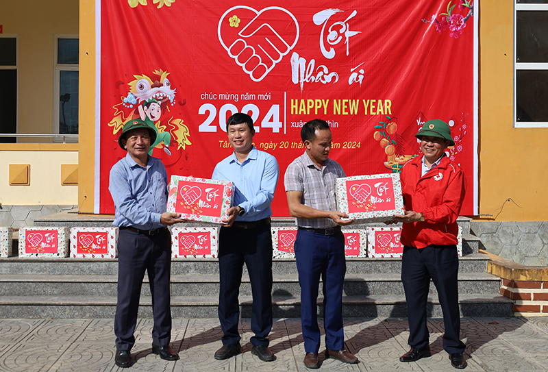 Đồng chí Phó Bí thư Thường trực Tỉnh ủy Trần Hải Châu và đại diện lãnh đạo Hội Chữ thập đỏ tỉnh tặng quà cho cán bộ, nhân dân và Trường phổ thông Dân tộc bán trú TH-THCS Tân Trạch.