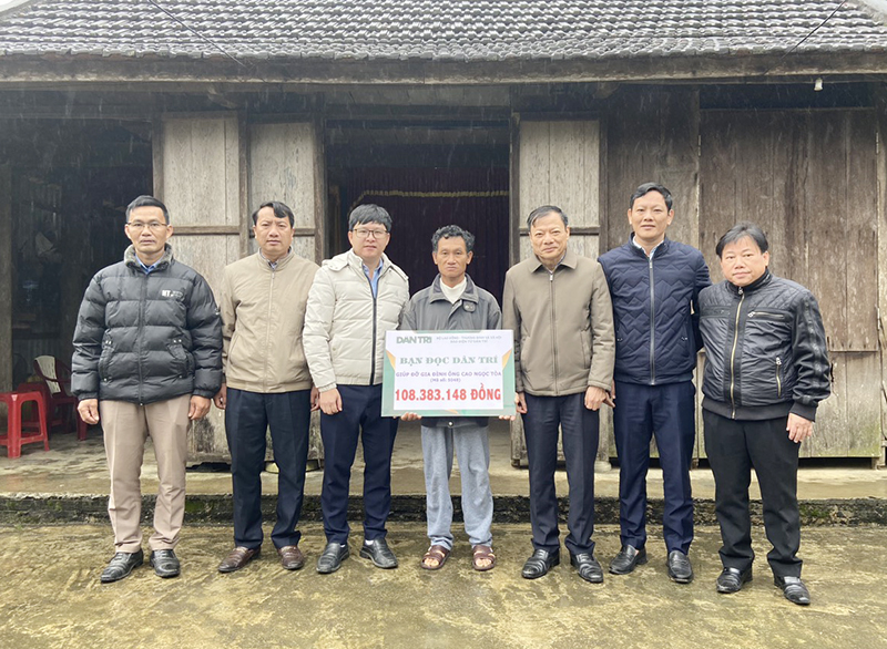 Phóng viên Báo Dân trí và các cấp uỷ, chính quyền địa phương huyện Minh Hóa trao số tiền hỗ trợ cho gia đình ông Cao Ngọc Tòa.