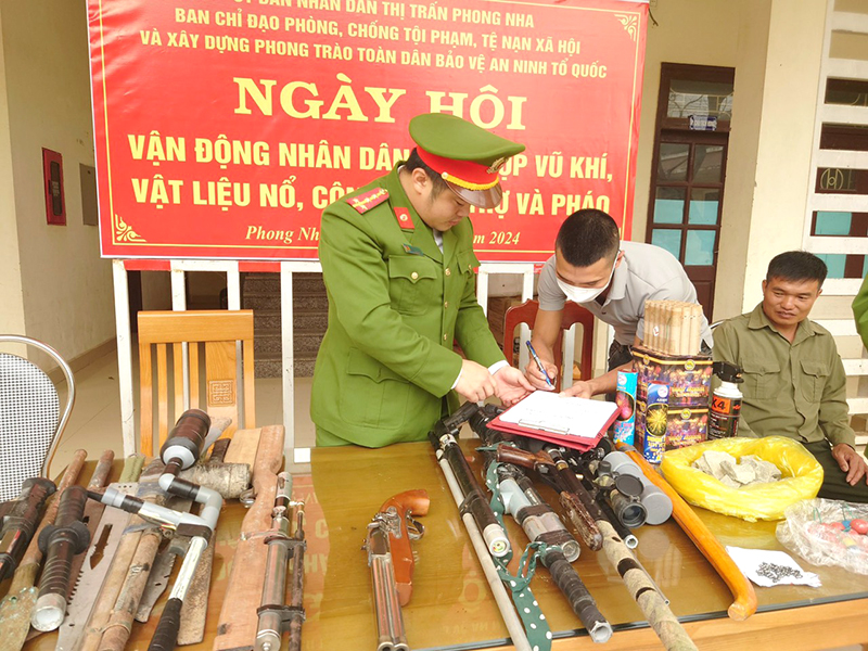 Công an thị trấn Phong Nha hướng dẫn người dân ký cam kết sau khi giao nộp vũ khí, vật liệu nổ và pháo.