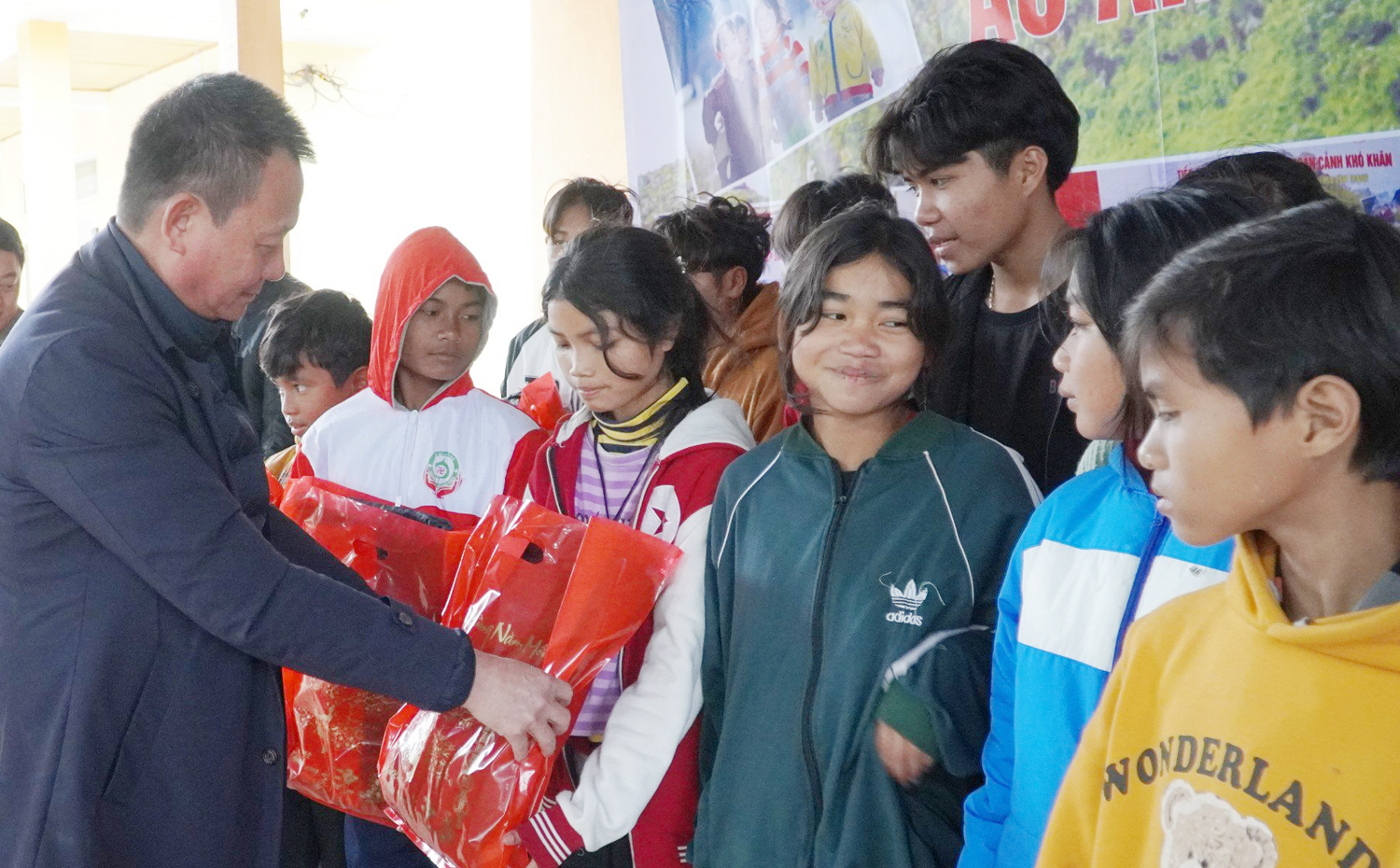 Lãnh đạo Trung tâm Kiểm soát bệnh tật Quảng Bình thay mặt nhà tài trợ trao áo ấm cho học sinh Trường Phổ thông dân tộc bán trú tiểu học và THCS Thượng Trạch.