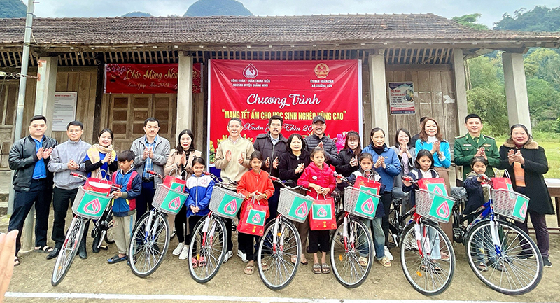 Các em học sinh nghèo xã Trường Sơn vui mừng đón nhận những chiếc xe đạp do các cán bộ viên chức PGD NHCSXH huyện Quảng Ninh trao tặng