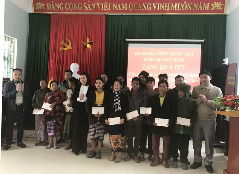 Đồng chí Phó trưởng đoàn chuyên trách Đoàn ĐBQH tỉnh Nguyễn Minh Tâm trao quà cho các hộ đồng bào người Arem ở xã Tân Trạch.