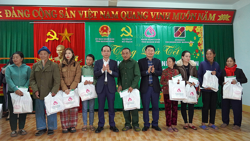  Đồng chí Phan Mạnh Hùng, Tỉnh ủy viên, Phó Chủ tịch UBND tỉnh và lãnh đạo Chi nhánh Ngân hàng Chính sách xã hội tỉnh tặng quà cho các hộ gia đình chính sách xã Lâm Trạch