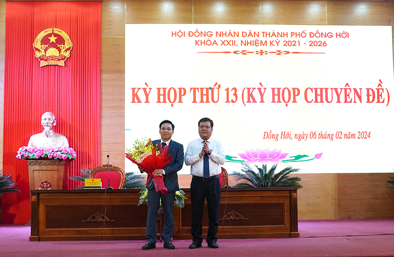 Đồng chí Trần Phong, Ủy viên Ban Thường vụ Tỉnh ủy, Bí thư Thành ủy Đồng Hới, Chủ tịch HĐND thành phố tặng hoa chúc mừng đồng chí Nguyễn Trung Kiên.
