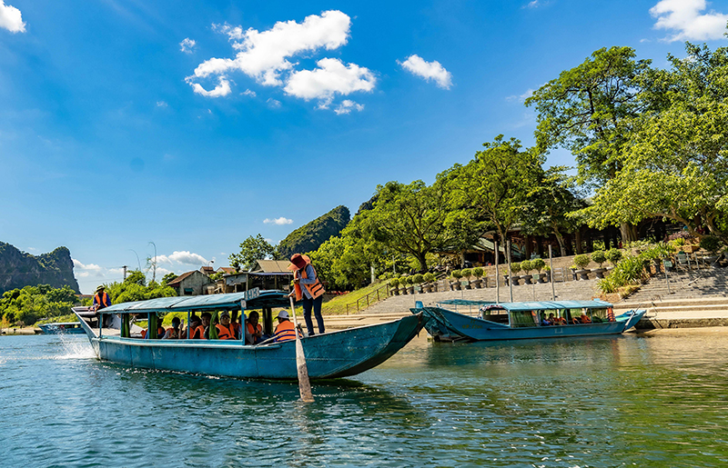 Du khách được ngồi thuyền ngắm cảnh sông nước hữu tình trước khi tham quan động Phong Nha-Tiên Sơn (Ảnh Trung tâm Du lịch PN-KB).