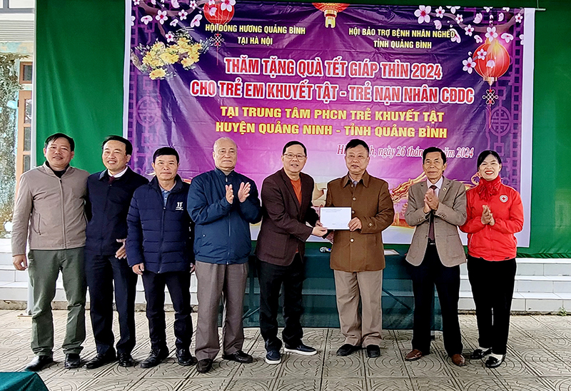 Ông Nguyễn Đức Tuấn (người đeo kính) thay mặt Hội đồng hương Quảng Bình tại Hà Nội thăm và trao quà Tết tại Trung tâm phục hồi chức năng trẻ khuyết tật huyện Quảng Ninh