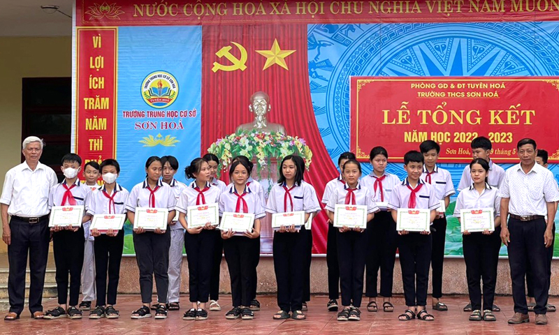 Ông Phan Xuân Tiến (ngoài cùng bên trái) trao thưởng cho các học sinh tại Trường THCS Sơn Hóa.