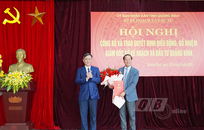 Đồng chí Chủ tịch UBND tỉnh Trần Thắng trao quyết định và tặng hoa chúc mừng đồng chí Giám đốc Sở Kế hoạch và Đầu tư Nguyễn Xuân Đạt.