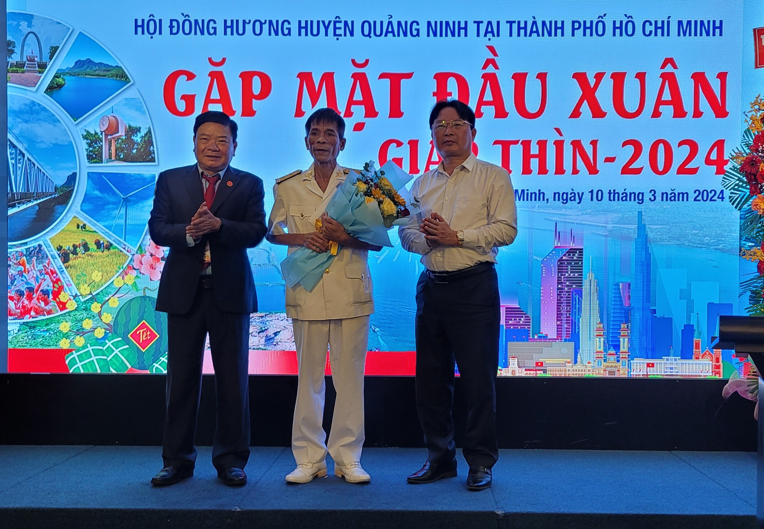 Đại diện lãnh đạo huyện Quảng Ninh và đại diện Hội đồng hương huyện Quảng Ninh tại TP. Hồ Chí Minh tặng hoa cho Anh hùng lực lượng vũ trang nhân dân Nguyễn Văn Lanh.