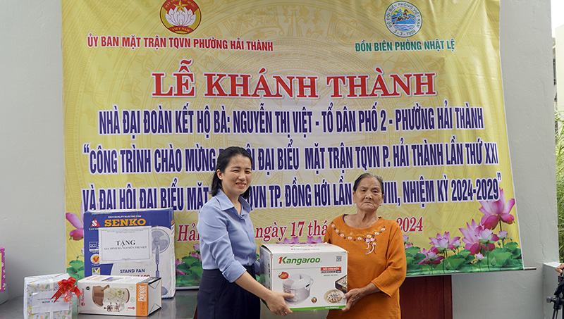 Đại diện lãnh đạo UBND phường Hải Thành trao quà cho bà Nguyễn Thị Việt