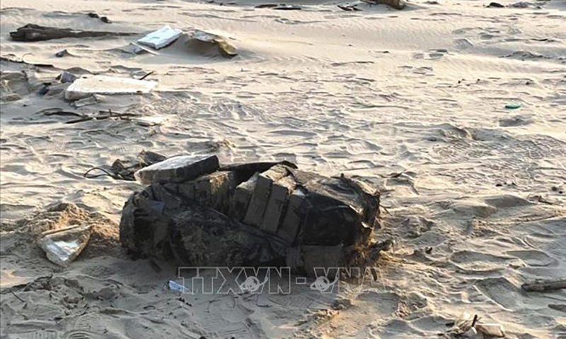 Túi màu đen chứa 20 bánh tinh thể màu trắng nghi ma túy trên bờ biển được phát hiện vào sáng 6/3. Ảnh TTXVN phát
