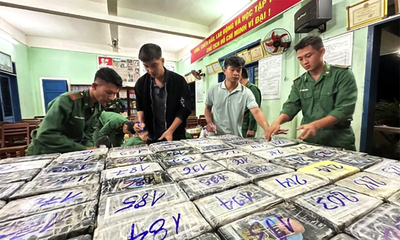 Lực lượng chức năng kiểm tra các gói nghi ma túy trôi dạt vào bờ biển gành Nước Nhỉ (Bình Sơn, Quảng Ngãi).